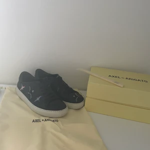 Arigato sneakers - Sneakers från arigato i storlek 38. Köpta på Axel arigato för 1850 kr. Distrahera, pinnar, kartong och kvitto finns om man vill ha med detta. Använda och lite slitna på vissa kanter men är ej sönder. Kan både mötas upp och leverera skorna💕