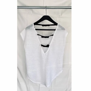 Vit topp med flugor/ rosetter på ryggen - Vit topp med svarta flugor/ rosetter på ryggen från SuiteBlanco storlek XS