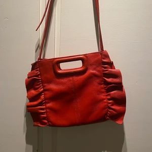 Maje väska röd - Säljer min älskade maje väska då jag inte får lika mycket användning av den längre!❤️🙌🏻 köpt på Vestiaire Collective och finns ej att köpa längre ifrån maje!🙌🏻 frakt tillkommer🚚 pris kan diskuteras om snabb affär! Ingen dustbag tyvärr!🙌🏻🙌🏻en liten defekt där bak som ni kan se på bild 3 men inget man lägger märke till!❤️🙌🏻 STORA MODELLEN! PRUTA PÅ!!! SÄLJER FÖR 1200kr PÅ DIREKTEN