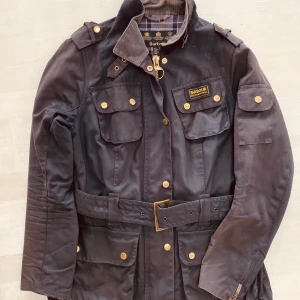 Barbour Damjacka - Passform: Classic/ Regular Yttermaterial: heavyweight 8oz barbour sylkoil vax Foder: 100% bomull barbour tartan Dragkedja med tryckknapp Tål ej maskin- eller handtvätt Tål ej kemtvätt