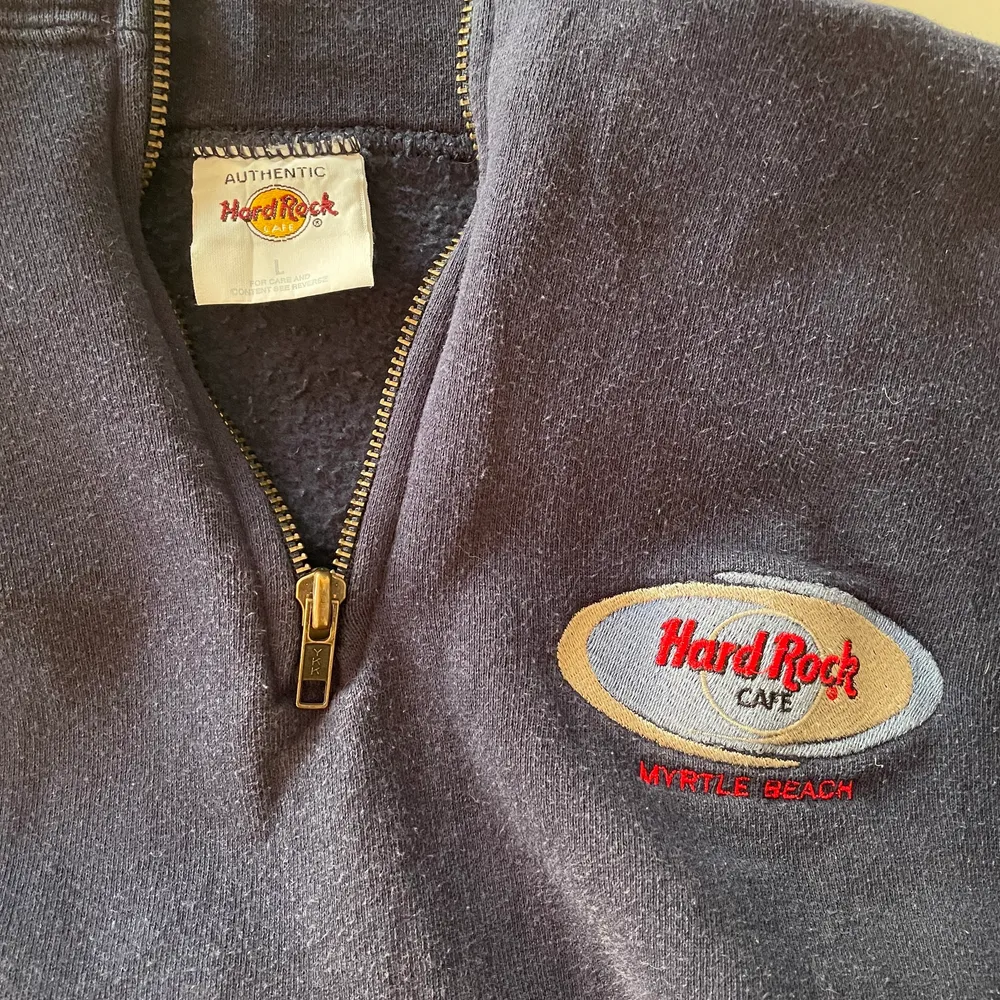 Mörkblå tröja med halv dragkedja från Hard Rock Cafe. Lite nopprig men inte så mycket som det ser ut att vara på sista bilden.. Tröjor & Koftor.