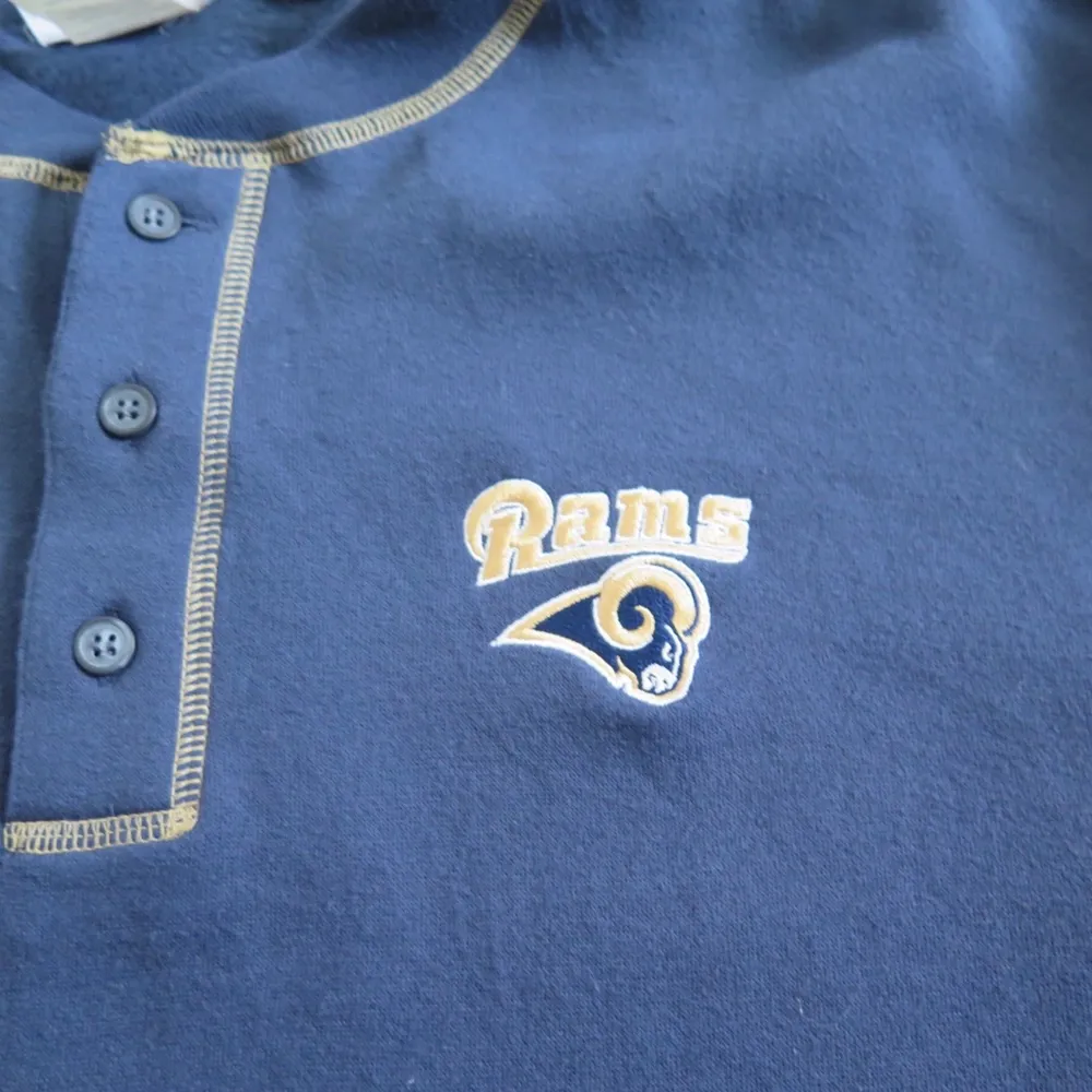 Rams NFL sweatshirt med knappar vid kragen strl L. Passar bra som oversize om man har mindre strl :) 66 kr spårbar frakt.  Skicka meddelande vid frågor/fler bilder! Notera att små defekter kan finnas då den inte är ny. Större brister nämns tydligt i annonsen/visas på bild. OBS! Bud är bindande!!!!!!! . Hoodies.