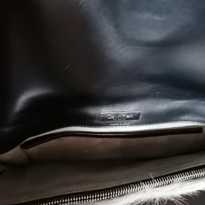 Oanvänd Calvin Klein faux fur clutch  - Clutch från Calvin Klein collection. Stängs med ett bälte i svart läder och silverfärgad metall. Ett sidofack inuti. Grå fuskpäls. Helt oanvänd gåva som bara ligger här och aldrig blir använd. Skicksr fler bilder om det önskas. Jag möts gärna upp upp eller skickar spårbart :). 