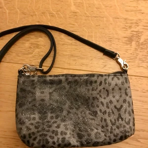 Väska  - Leopard mönstrad, silvrig väska. Går att ta bort band.     20kr +frakt