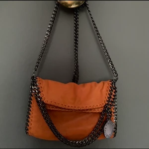 Stella McCartney väska - Orange Stella McCartney väska som är väl använd. Äkta, köpt av Lovisa Wallin, men säljs billigt på grund av det slitna skicket. 