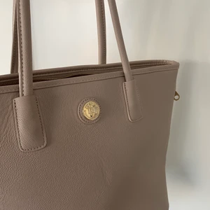 Rymlig väska i beige - Praktisk, stilren väska i beige med många rymliga fack. Nyskick. Exklusive frakt