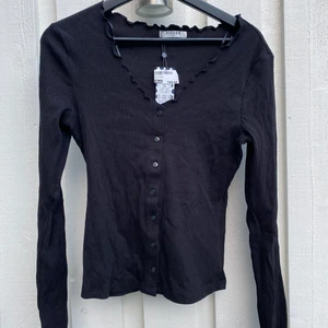 Ribbad tröja - Gullig, ribbad topp med knappar framtill som detalj. 🛍 märket heter PIECES och tröjan är köpt på Thun’s men är som ni ser oanvänd eftersom att lappen sitter kvar. Jag säljer den för att jag inte har använt den och inte kommer göra 😌 så den är verkligen i nyskick!