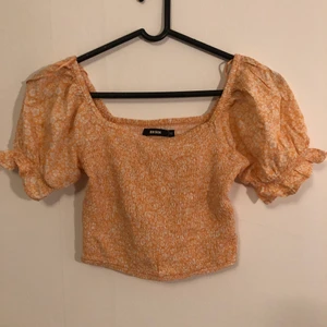 Blommig top - Jättesöt top från bik bok i färgen aprikos, den är i storlek XS 