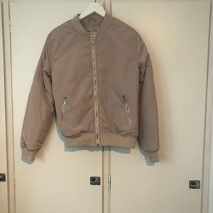 Bomberjacka från Madlay storlek 8 - Beige bomberjacka från Madlady. Jackan är i en mer kall beige ton i verkligheten. Jackan är aldrig använd och prislappen sitter kvar. 