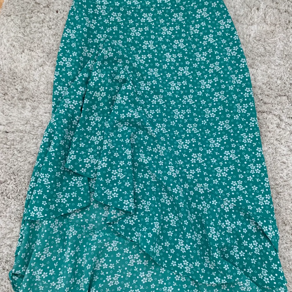 En grön kjol med blommor på från Cubus. Perfekt till sommaren! I storlek 34 men passar till 36 också.. Kjolar.