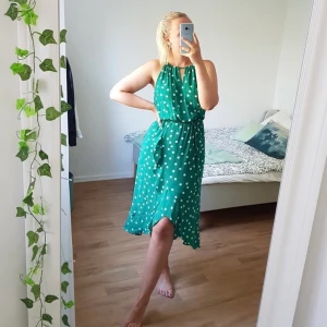 OASIS PRICKIG KLÄNNING  - Grön chiffong klänning med vita prickar. Volang nertill, snöre i midjan & i nacken. Bara använd knappt en handfull gånger så i fint skick! Perfekt till bröllop eller annat sommar event! 