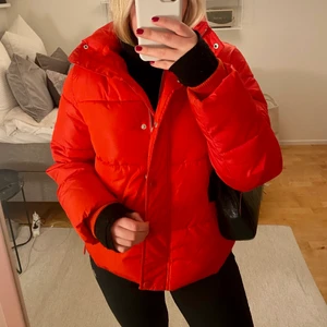 Röd dunjacka  - Säljer min röda puffiga dunjacka från HM då jag inte använder den längre. Mjuk, varm och ganska stor, perfekt för kyligare dagar. Fint skick, använd ett fåtal gånger. Finns resår längst ned för att justera storleken runt höften. Fraktar endast och köparen står för frakten. 🤍