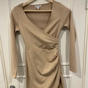 Festklänning från Nelly - En beige festklänning från Nelly använd 2 gånger 