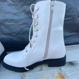 Kängor/ vinterskor  - Fina pärlemo-vita vinterskor, nya i kartong från JustFab. Stl. 38,5. Blir nog ganska dyra att skicka, men bor i Nacka. Kan tänka mig att mötas upp i tex. Nacka Forum, Sickla eller Globen C, 