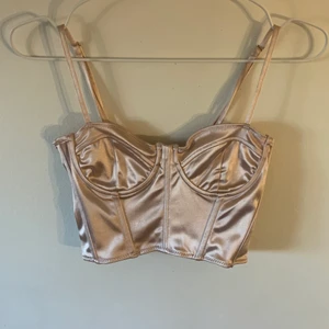Rosa korsett top - Rosa korsetttopp i glansigt silkesaktigt material. Aldrig använd lapp kvar