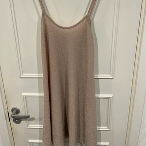 Glittrig festklänning  - Glittrig fest klänning med spagetti band! Slutar ungefär ovanför knäna. Aldrig använd köpt i England 