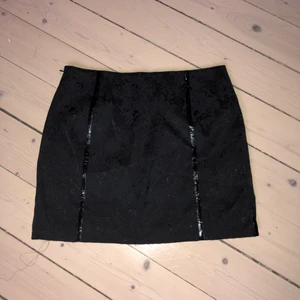 Svart minikjol med detaljer - Svart kjol med spetsdetaljer och slitsar och detaljer i ”lack”. Köpt på humana för ca 1 år sen. Är för liten därför säljer jag den tyvärr. Storlek Xs . Köparen står för frakten💓