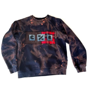 Tie-dye bleached svart sweatshirt - Hemmagjord tie-dye bleached svart sweatshirt med applikation. Köpte den svarta sweatshirten second hand o har sen diy-at o blekt o gjort applikation på den. Tröjan är som sagt second hand men hel, ren och har inga hål eller liknande. Säljer då den är för liten för mig. 