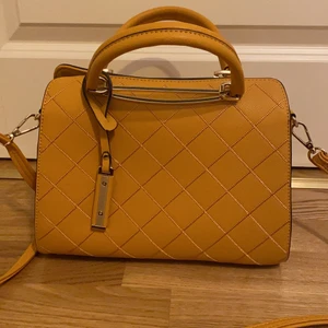 VÄLDIGT FIN VÄSKA - En väska med normal storlek och en väldigt fin nyans av orange. Väskan har mycket utrymme till skaker. Rekommenderar verkligen!