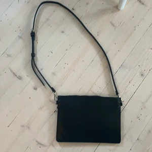 Svart väska Carin Wester - Oanvänd väska i skinn-imitation. 26x18 cm. Vid köp av annan vara av mig så får man denna på köpet 