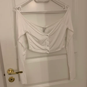 Vit offshoulder topp Nelly nly trend - Säljer denna vita supersöta topp från Nelly! Aldrig använd så prislapp kvar! Säljes endast då jag glömde skicka tillbaka💗✨