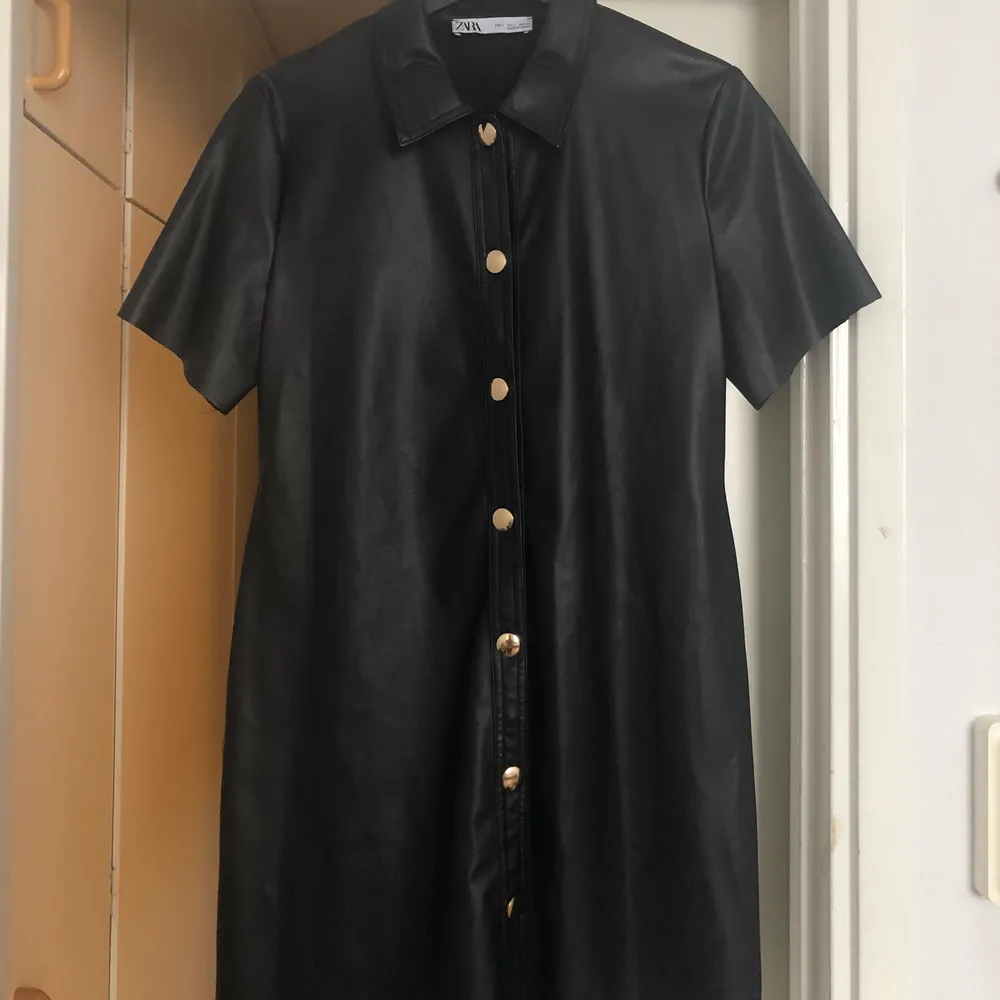 Black boxy leather dress with pockets and golden buttons from Zara. Klänningar.