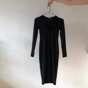 Svart klänning  - Svart tight klänning med V-ring. Går till låren men jag är också 1.78 cm. Använd fåtal gånger. Säljes pga flytt. Frakt tillkommer 🚚