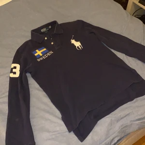 Ralph Lauren piké tröja (Sweden Edition) - Säljer en jättefin pikétröja från Ralph lauren i färgen marin blå som är en gammal kollektion där dom gjorde pikétröjor med flera olika flaggor, den är inköpt på Jaber mode som nu har gått i konkurs i Uppsala och köptes för 1799kr     Kan tänka mig gå ner ytterligare i pris med endast vid snabb affär Kondition ca 7 / 10