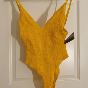 Baddräkt 💛  - Sjukt snygg baddräkt från Nelly. Den är skuren så den går upp högt på höfterna och lagom v-ringad 💛 aldrig använd så helt ny! köpt för 299kr