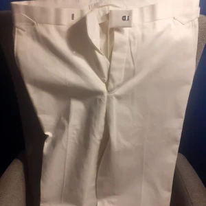 Vita bomulls byxor Bladen - Ett par oanvända vita lite tjockare bomulls byxor från Brittiska Bladen. Helt oanvända. Har bara legat i garderoben. Byxorna har rålängd och behövs läggas upp. Inga bälteshällor utan sidosjusterare.