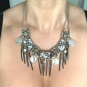 Bohemiskt halsband  - Snyggt silverfärgat bohemiskt halsband med tygbitar samt små mynt detaljer. Porto 24kr, kan hämtas hos mig i Solna.