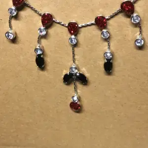Fint halsband med röda och mörka detaljer, köparen står för frakt!