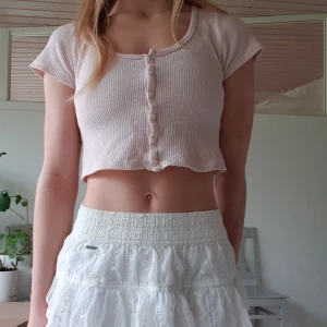 Zelly crop top brandy melville - Ljusrosa croptop med knappar från Brandy Melville. Den är köpt second hand och är därför i använt skick (se bild 3). Storlek "one size" men eftersom den är stretchig så skulle jag uppskatta storleken till XS-M beroende på vilken passform som önskas. Frakt tillkommer!💞