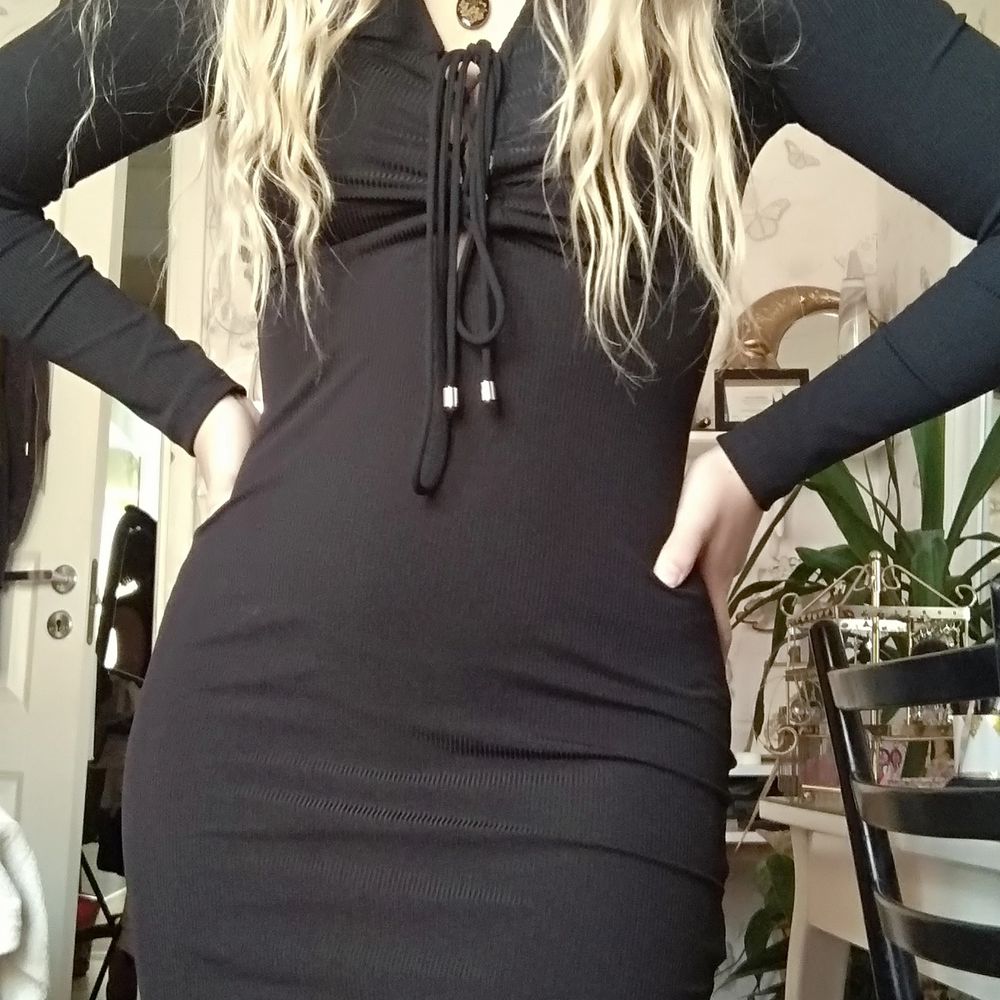 Tight svart klänning med långa snören som snöras över bröstet, snörena är justerbara. Långa armar och klänningens längd går till mitten av mina lår, jag är 161 cm lång. Mjukt tyg som inte skaver. Säljer p.g.a att jag aldrig använder den. Pris kan alltid diskuteras! . Klänningar.
