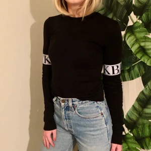 Back långärmad t-shirt - Långärmad t-shirt från back med elastiska band över armarna i svart och vitt. 