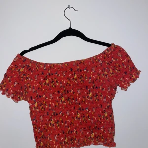 Röd blommig off shoulder tröja - Har använt tröjan några gånger och den kommer ifrån BikBok. Jätte fin att ha till jeanskjol eller ett par blåa jeans. Sitter jätte bra på och är inte alls för tajt eller för stor. 