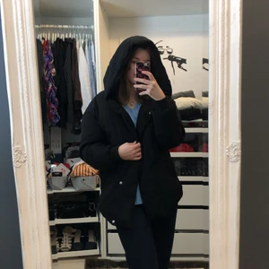 Svart jacka med luva  - Tunnare vinterjacka med stor Luva. Går både att klä upp och ner. Storlek: S och passar mig som normalt har S. Pris är exkl frakt