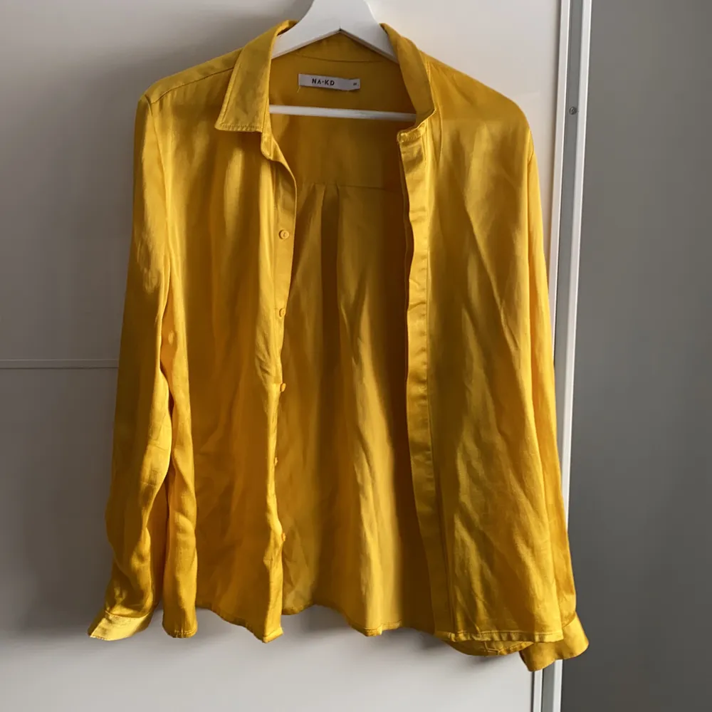 En gul skjorta från nakd. Använd men är i nytt skick. Första bilden är liknande, skillnaden är att på den jag säljer syns inte knapparna när den är knäppt. . Skjortor.
