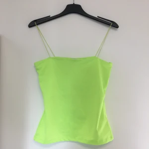 Neongrön topp - Neongrön topp med smala spagettiband. Mer lysgrön i verkligheten än på bilden. Storlek XS men passar S också.