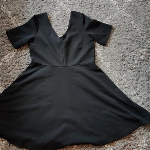 Klänning, H&M+, strl L - Köpt begagnad i nyskick, aldrig mer än testad av mig och troligen inte av förra ägaren heller eftersom den känns som ny. Djupt V-ringad i både rygg och över brösten. Svart färg. Kjolen slutar precis ovanför knäna på mig (173cm). Samfrakt med andra annonser möjlig. 