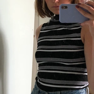 Turtleneck topp - Svartvitt turtleneck linne köpt second hand. Står storlek L/XL men passar mig som vanligtvis har S!