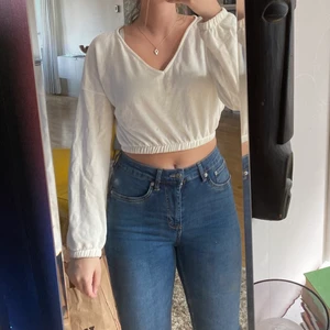 Stickad tröja från nelly - Jättefin stickad tröja från Nelly som är croppad. V-ringad både på framsidan och baksidan. Lite offwhite. Kan mötas upp i Mjölby, annars står köparen för frakt!!