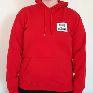 Röd hoodie med tryck - Klassisk hoodie i mycket bra begagnat skick, genomgående ficka på framsidan, färgen något mörkare röd än på bilderna. Hund finns i hemmet. Tar bara swish.
