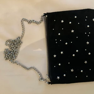 Väska med silverstjärnor  - Jättefin väska i mocka med silversjtärnor på med silverskeds som axelband. Väldigt bra skick och knappt använd.