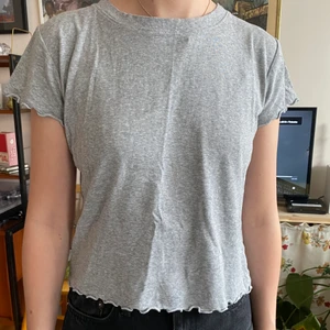 T-shirt med volang - Grå t-shirt med volang i bomull från Bikbok. Storlek M. 