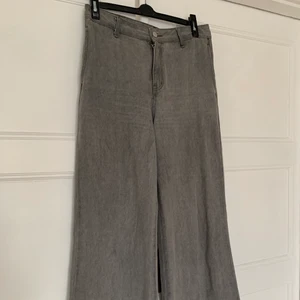 Grå vida jeans - Säljer dessa vida ljusgrå jeans. De har inga bakfickor och är formade som kostymbyxor med jeansmaterial. På sidorna i höfthöjd finns det en ficka på vardera sida. De är använda 1-2 gånger och har gott skick. De är inte min stil och därför säljer jag dem.