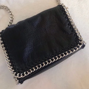 TIAMO väska svart  - Väska från från TIAMO köp på scorett för 500kr men säljer nu för 300kr + frakt. Väskan är i nyskick då jag bara använt den en gång. Det finns ett litet fack på baksidan av väskan och även ett inuti med dragkedja.✨💕  kan mötas upp. Först till kvarn ❗️