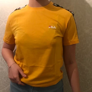 Fila t-shirt  - en skitsnygg gul tisha från junkyard i märket fila som jag använt några gånger. nyskick. passar XS-M beroende på hur man vill att den ska sitta! säljer pga inte min stil längre