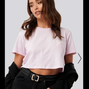 Rosa Croppad T-Shirt - Fin rosa croppad T-shirt från NA-KD. Använd ett fåtal gånger och är därför inte alls sliten. Säljer för att den är för liten (säljer även en likadan i svart) Ordinarie pris är 149kr. Bjuder på frakten tills den 2:e April.