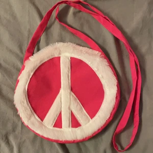 Väska - Rosa väska! Man öppnar och stänger väskan med kardborre som syns på andra bilden❣️ diametern är 24cm och bandet är ganska långt men går lätt att göra en knut av för att bli kortare!